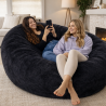 femmes allongées sur un pouf long géant en fausse fourrure