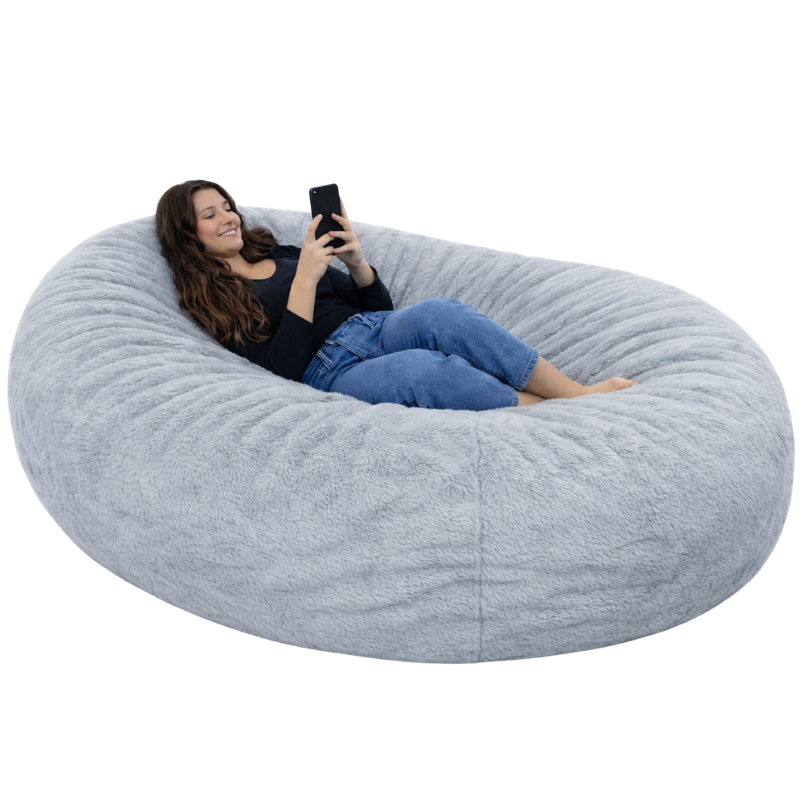 femme allongée sur un pouf long géant en fausse fourrure