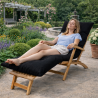 femme allongée sur un coussin bain de soleil dans un jardin