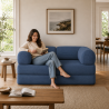 femme assise sur un canapé lit modulable en velours côtelé