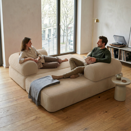 couple assis sur un canapé lit modulable en velours côtelé