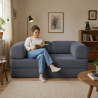 femme assise sur un canapé lit modulable en velours côtelé